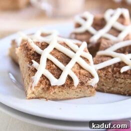 Cinnamon Roll Blondie Bars 8 four cinnamon roll bars on two stacked white plates