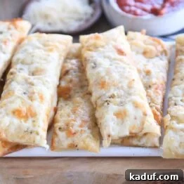 eight cheesy breadsticks on wood cutting board