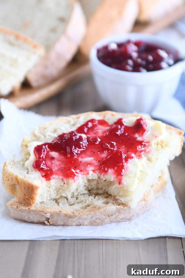 Effortless Rustic Sourdough Loaf 12 Two slices of sourdough peasant bread, with the top slice generously topped with jam and butter, a delightful serving suggestion.