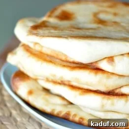 Stacked Naan bread on a blue plate, ready to be served with a curry.