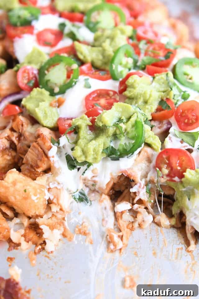 Ultimate BBQ Chicken Totchos 4 BBQ chicken tater tot nachos on sheet pan with helping taken out.