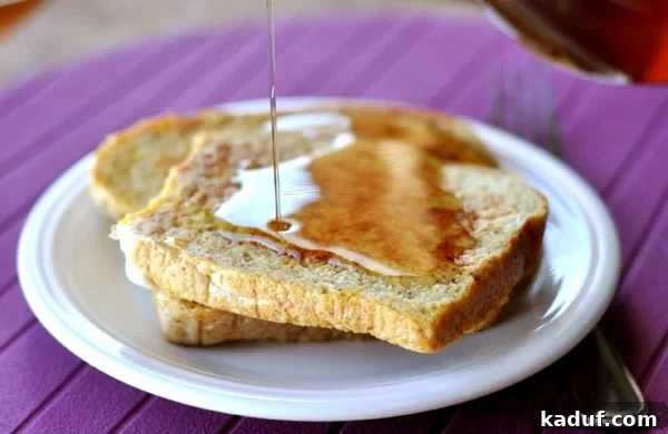 Golden Harvest Maple Syrup 3 A plate of French toast being generously drizzled with golden homemade maple syrup, ready to be enjoyed.