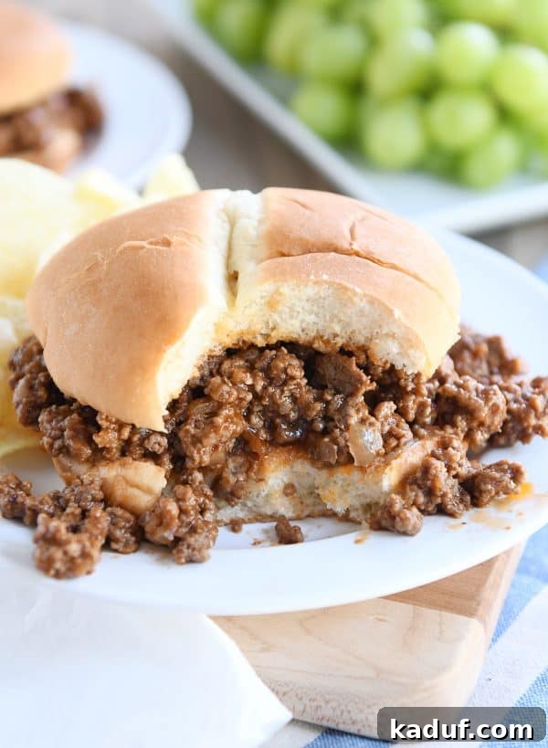 Seriously Delicious Sloppy Joes 5 A perfectly assembled sloppy joe on a white plate, with a bite taken out, revealing the rich, savory filling.