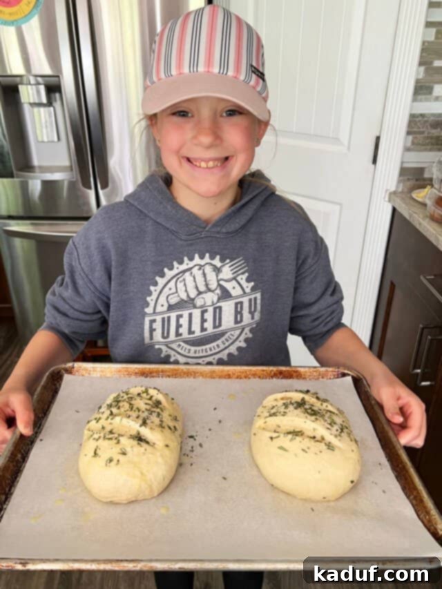 Friday Musings 7 Girl holding sheet pan with two loaves of bread.