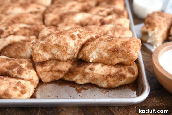 Fluffy Cinnamon Sugar Knots 3 Baked pan of cinnamon sugar twists with one piece stacked on top of another. These buttery cinnamon sugar twists are unbelievably delicious. Easier than cinnamon rolls, they are soft, fluffy and delicious plain or with a bit of sweet icing!