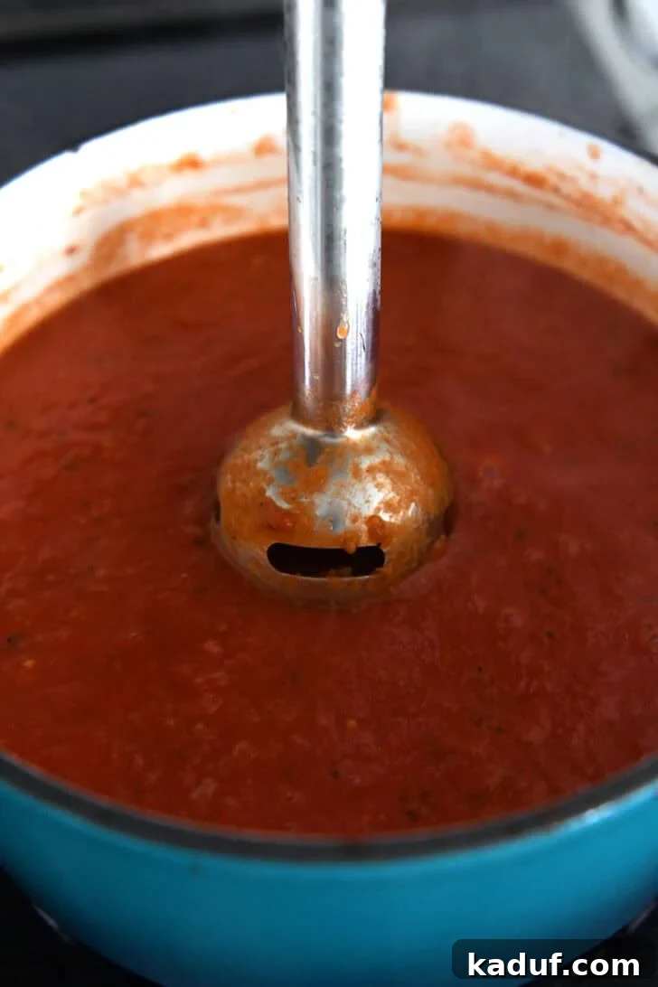 The Ultimate Tomato Soup Experience 5 Immersion blender blending tomato soup