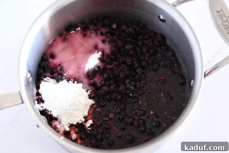 Grandma's Secret Sheet Cake Recipe 6 Huckleberries, sugar, cornstarch, and lemon juice in a stainless steel pot.