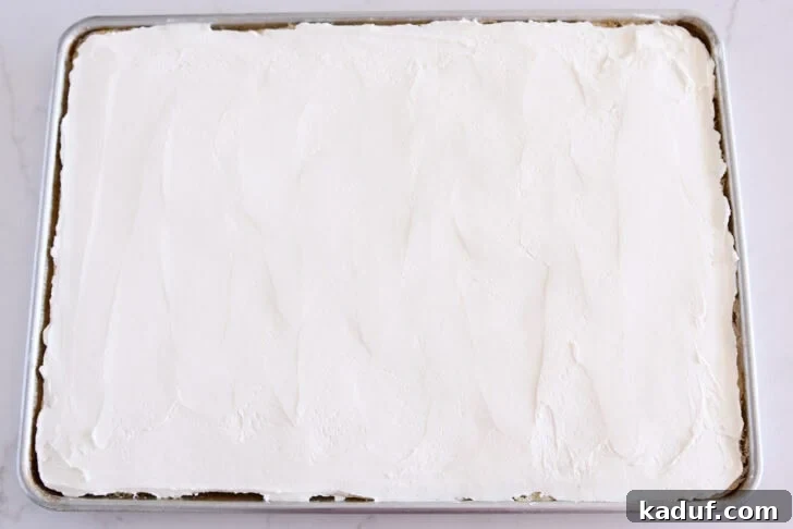 Grandma's Secret Sheet Cake Recipe 8 White sheet cake in a half sheet pan topped with the cream cheese layer.