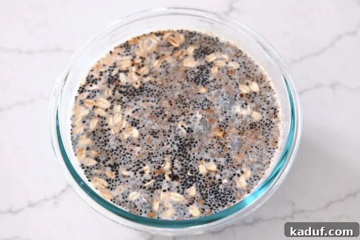 Best Ever Overnight Chia Oats 10 Glass bowl with almond milk, chia seeds, basil seeds, oats, cinnamon, maple syrup and salt
