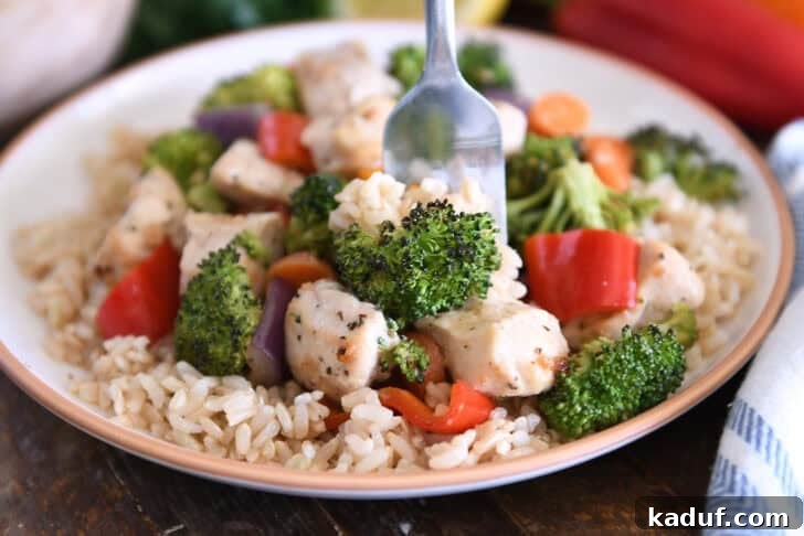 Sweet & Sticky Sheet Pan Chicken Dinner 6 Fork scooping bite of cooked chicken, brown rice, and broccoli.