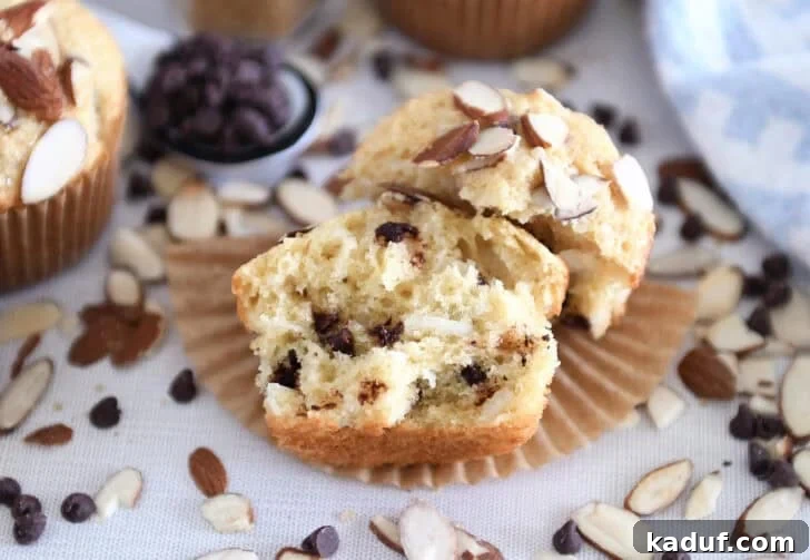 Decadent Almond Coconut Chocolate Chip Muffins 3 One almond coconut chocolate chip muffin broken in half on brown paper liner.