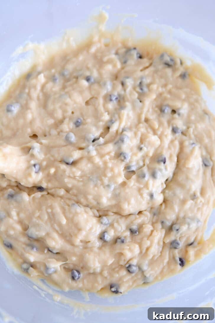 Decadent Almond Coconut Chocolate Chip Muffins 5 Almond coconut chocolate chip muffin batter in glass bowl.