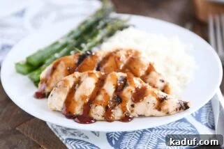 sticky coconut chicken on white plate with coconut rice and asparagus