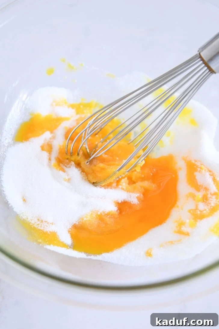 Homemade Banana Pudding from Scratch: Creamy Classic Recipe 4 Glass bowl with egg yolks and granulated sugar.
