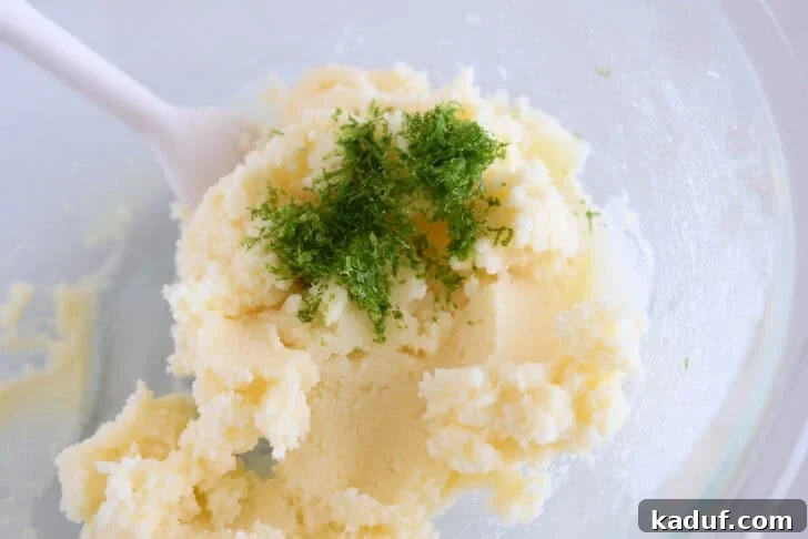 Glass bowl with creamed sugar, butter, and fresh lime zest.