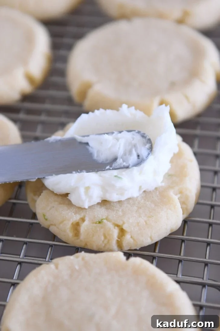 Frosting round sugar cookie with coconut lime frosting.