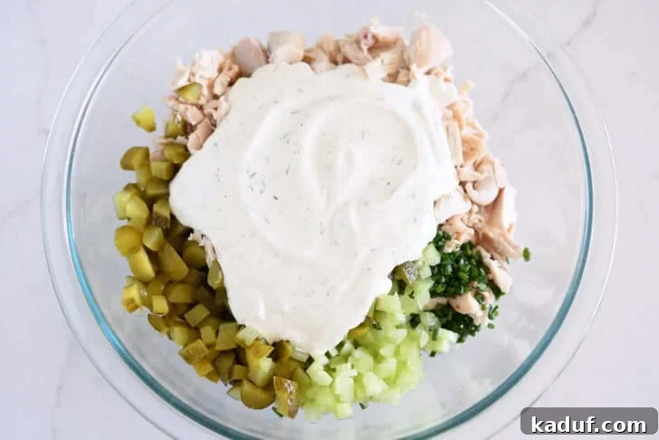 Tangy Dill Pickle Chicken Salad Recipe 6 Glass bowl with celery, chopped dill pickles, green onions, chopped chicken and creamy dressing.