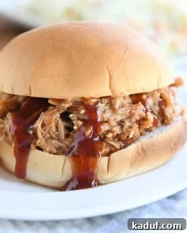 BBQ pork sandwich on bun on white plate