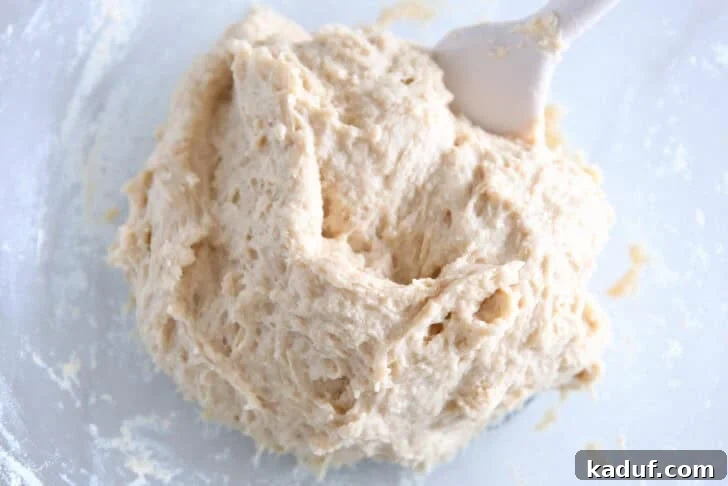 Fluffy Cinnamon Roll Bites: Mini Sweet Pastries 4 Wet roll dough mixed in glass bowl.