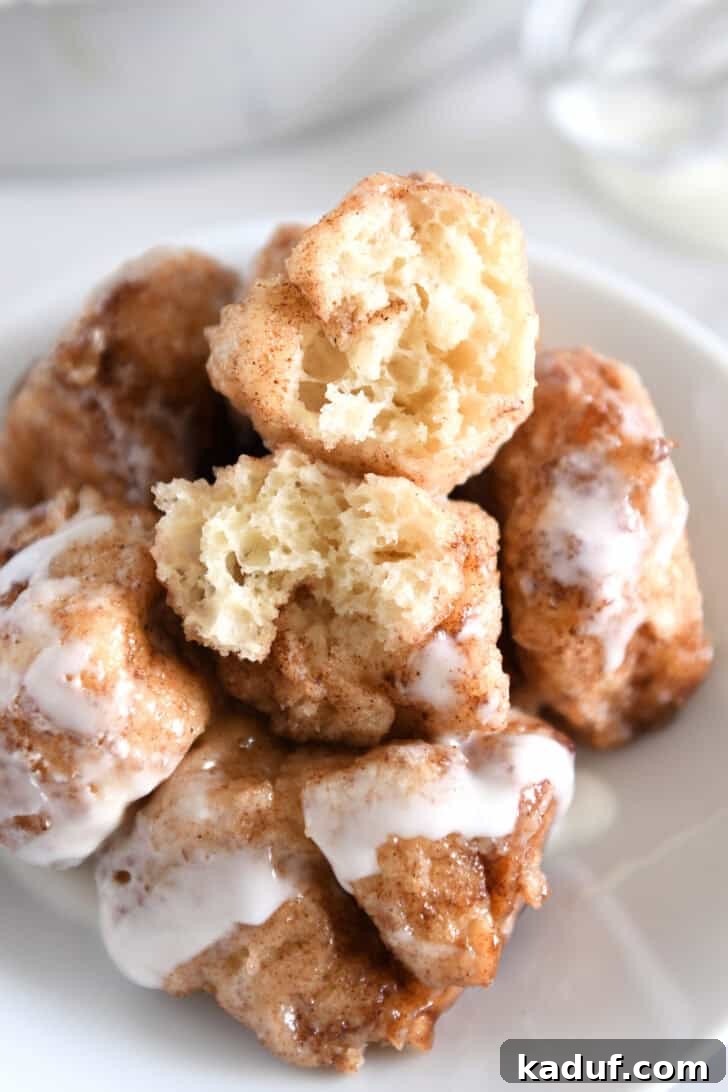Fluffy Cinnamon Roll Bites: Mini Sweet Pastries 9 White plate with five cinnamon roll bites drizzled with icing with top cinnamon roll bite in half.